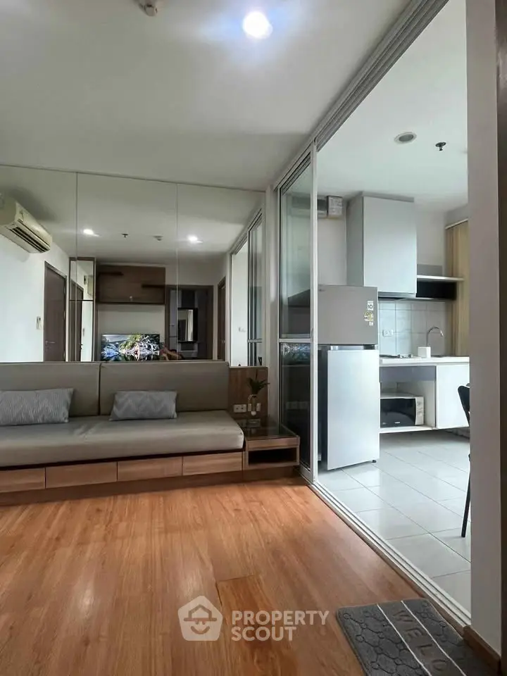 Modern living room with open kitchen layout and sleek wooden flooring