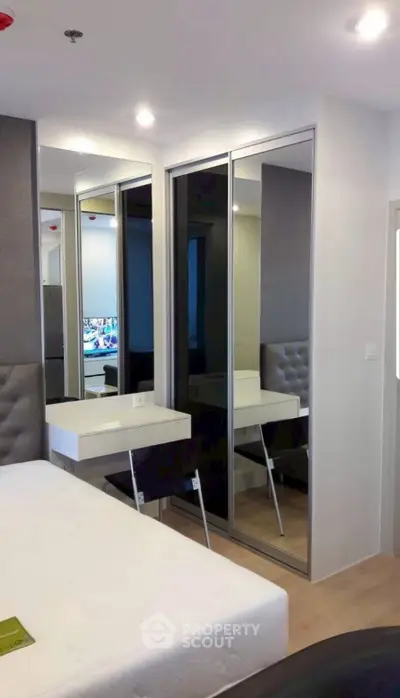 Modern bedroom with mirrored wardrobe and sleek design in a stylish apartment.