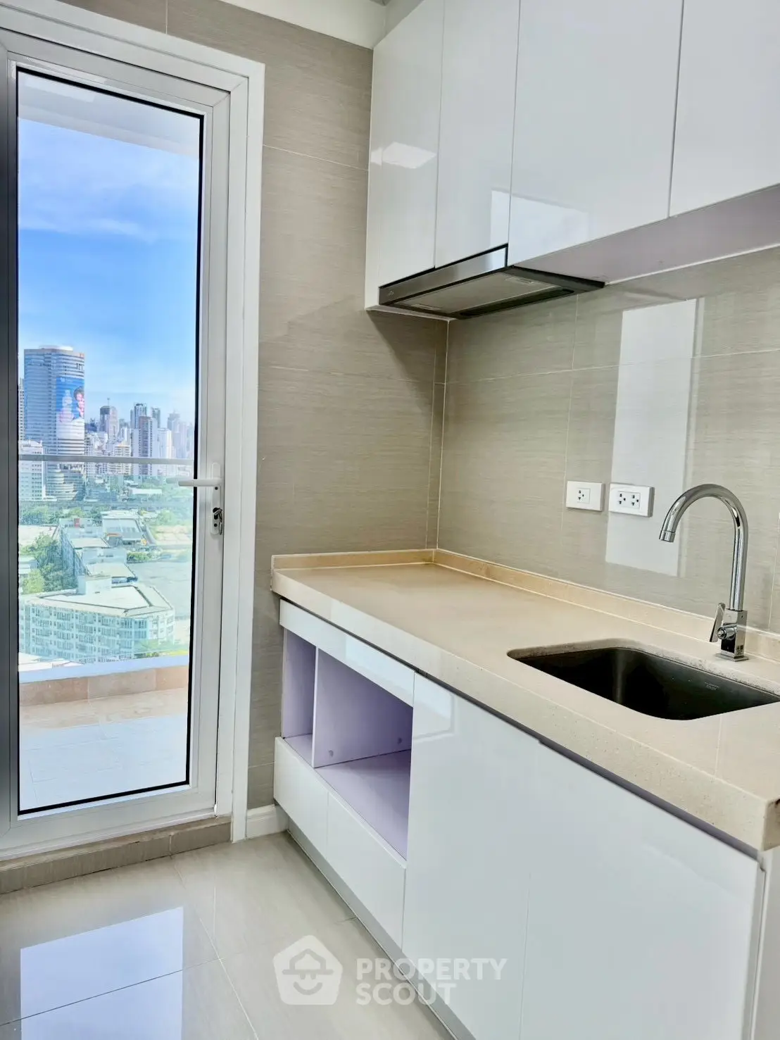 Modern kitchen with sleek cabinets and stunning city view from balcony.