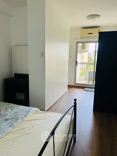 Bright bedroom with balcony access and modern furnishings in a stylish apartment.