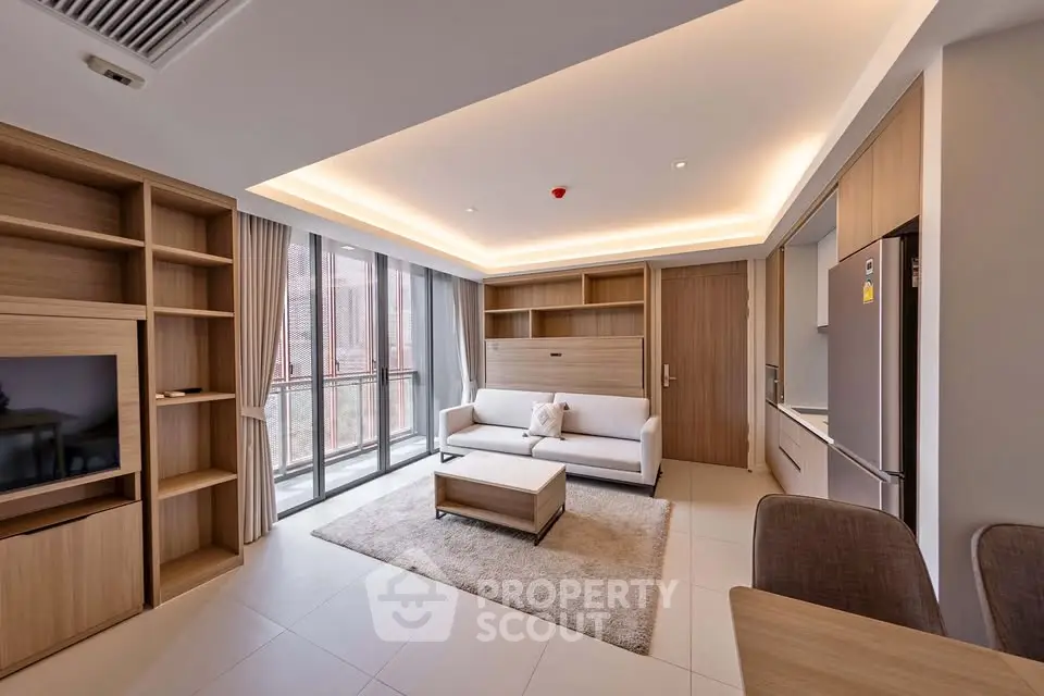 Modern living room with sleek furniture and large windows offering natural light.