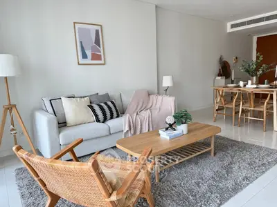 Modern living room with cozy decor and dining area, featuring stylish furniture and neutral tones.