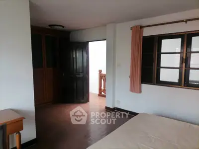 Spacious bedroom with wooden accents and natural light