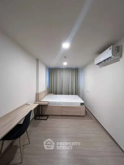 Modern minimalist bedroom with sleek design and air conditioning, perfect for comfort and relaxation.