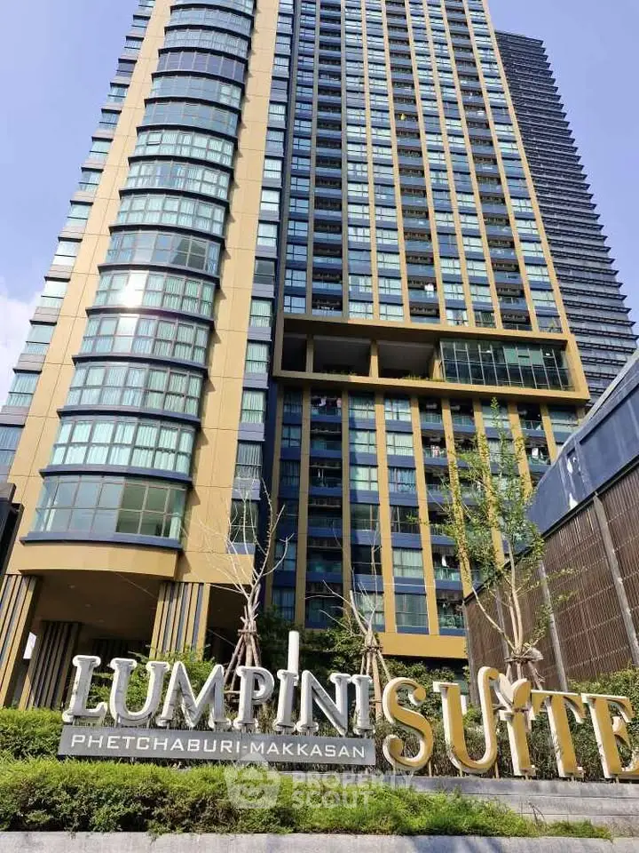 Modern high-rise building exterior of Lumpini Suite Phetchaburi-Makkasan with lush landscaping.