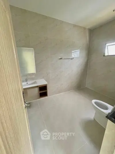 Spacious modern bathroom with elegant tiles and natural light.