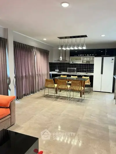 Modern kitchen with open layout, sleek appliances, and stylish dining area.