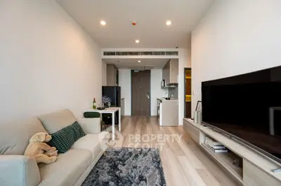 Modern living room with open kitchen, cozy sofa, and stylish decor in a contemporary apartment.