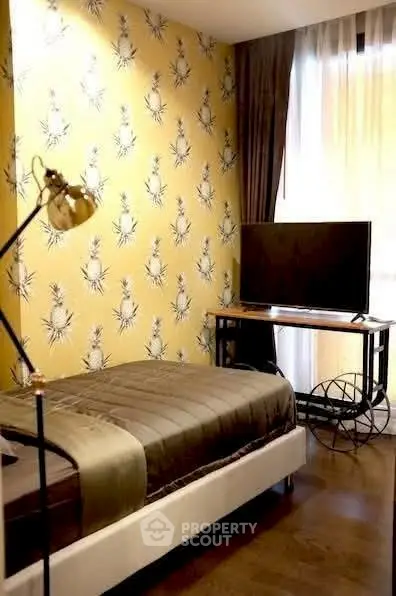 Chic bedroom with stylish wallpaper and modern TV setup, perfect for cozy living.