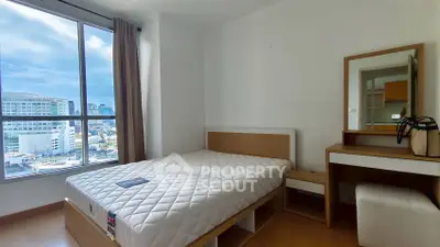 Modern bedroom with city view, featuring a cozy bed and stylish vanity set.