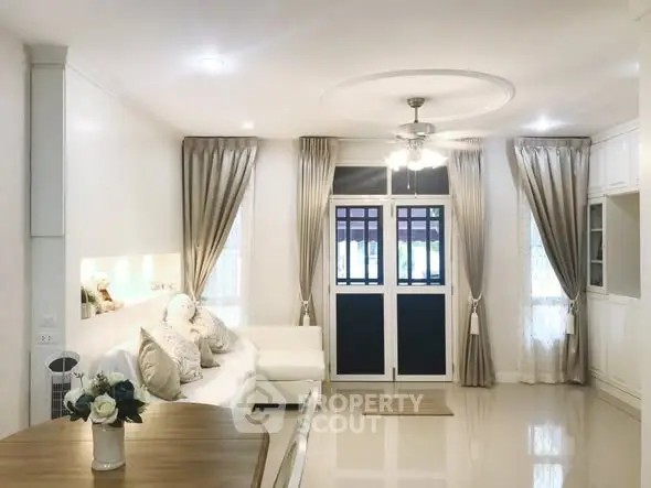 Elegant living room with modern decor and natural light, featuring a cozy sofa and stylish curtains.