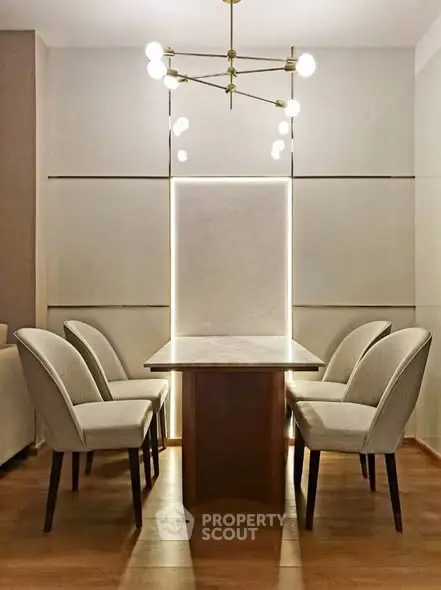 Elegant dining area with modern chandelier and stylish chairs in a cozy setting.