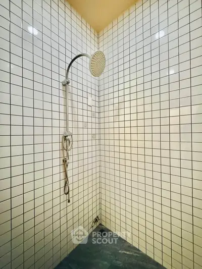 Modern shower area with sleek tile design and rainfall showerhead in a contemporary bathroom.