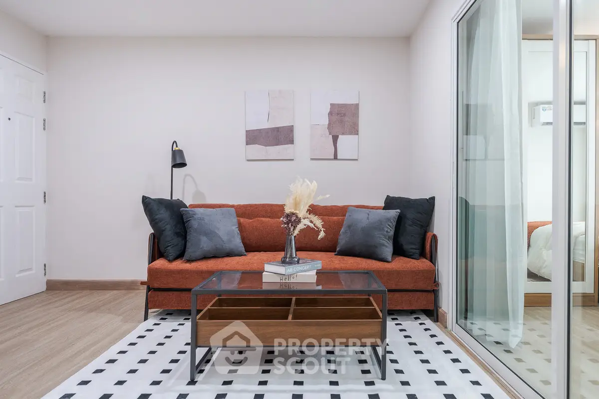 Modern living room with stylish decor and glass partition, featuring a cozy sofa and elegant coffee table.