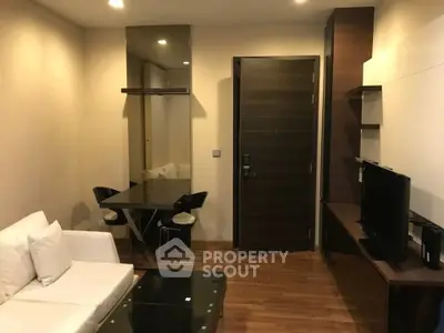 Modern living room with sleek furniture and wooden flooring in a cozy apartment.