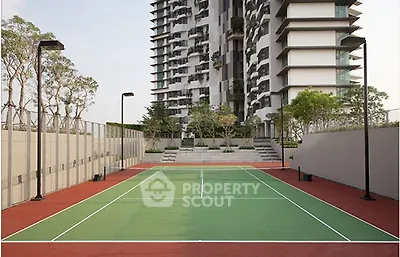 Modern residential building with tennis court and landscaped surroundings.