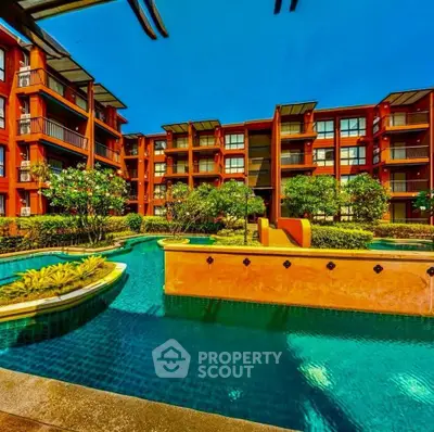 Luxurious apartment complex with stunning pool and lush greenery, perfect for resort-style living.