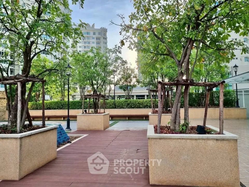 Beautifully landscaped garden area with trees and modern architecture in a residential complex.