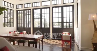 Spacious living room with large windows and elegant decor, perfect for modern living.