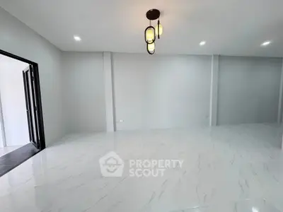 Spacious modern living room with elegant lighting and sleek tile flooring.