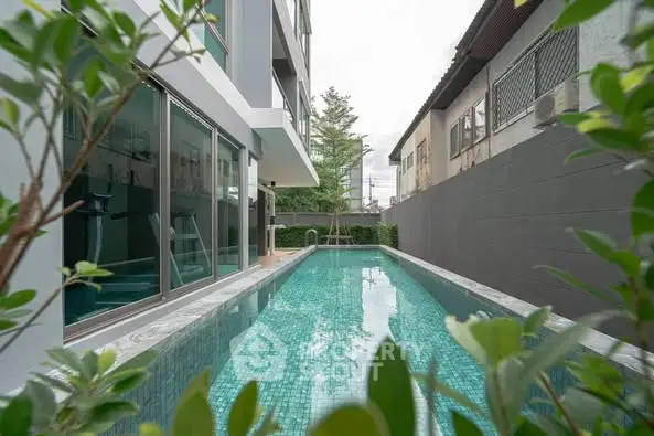 Modern apartment building with sleek swimming pool and lush greenery