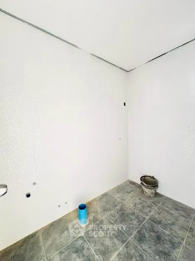 Spacious unfinished bathroom with tiled floor and white walls, ready for customization.
