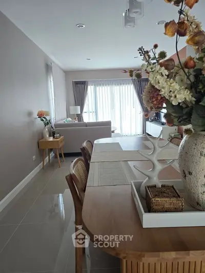 Elegant living room with modern decor and natural light, featuring stylish furniture and a cozy atmosphere.