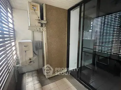Compact balcony with washing machine and sliding glass doors