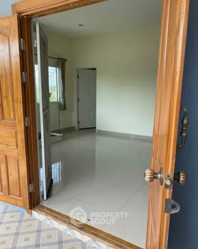 Spacious interior with wooden door and tiled floor, perfect for customization.