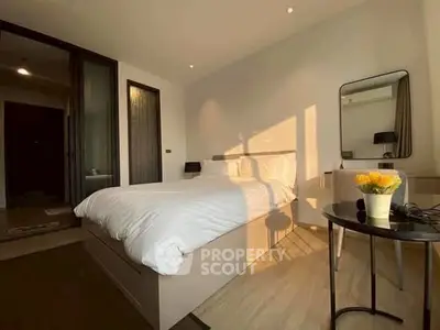 Cozy bedroom with modern decor and natural light, featuring a comfortable bed and stylish furnishings.