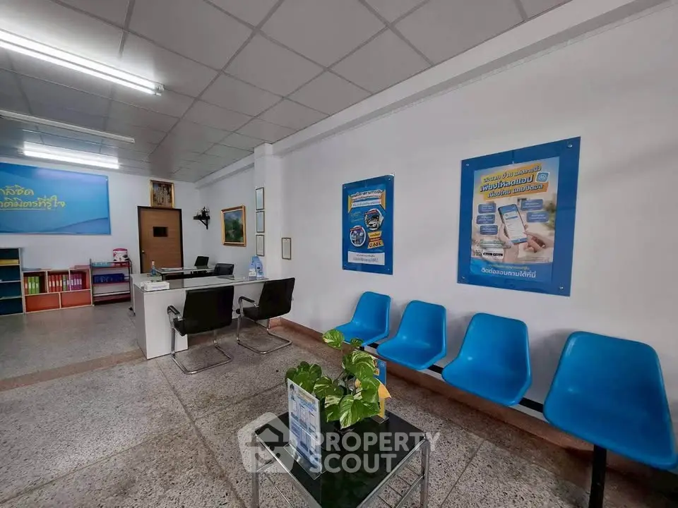 Spacious office reception area with modern seating and informational posters.