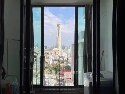 Stunning city view from a modern apartment balcony with floor-to-ceiling windows.
