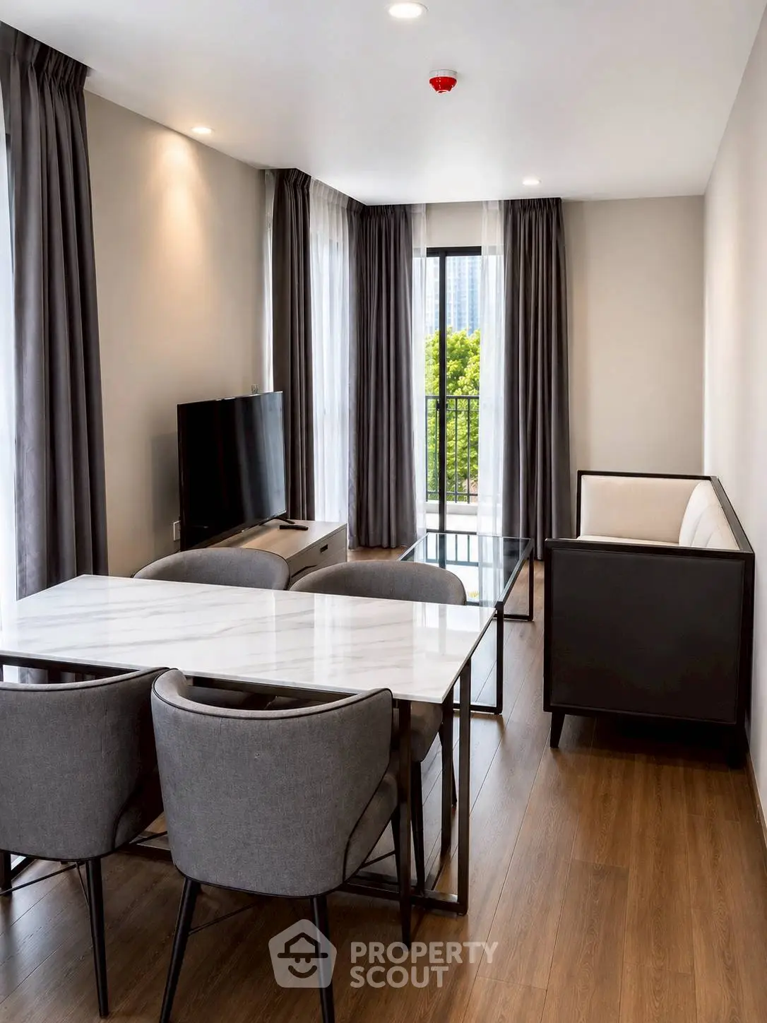 Modern living room with elegant furniture and large windows offering a city view.