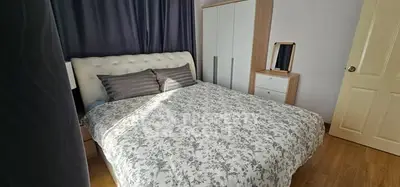Cozy bedroom with elegant decor and ample natural light, featuring a stylish bed and modern wardrobe.