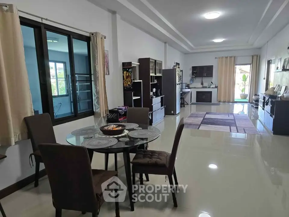 Spacious open-plan living and dining area with modern furnishings and large windows.