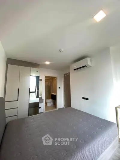 Modern bedroom with ensuite bathroom and air conditioning in a stylish apartment.