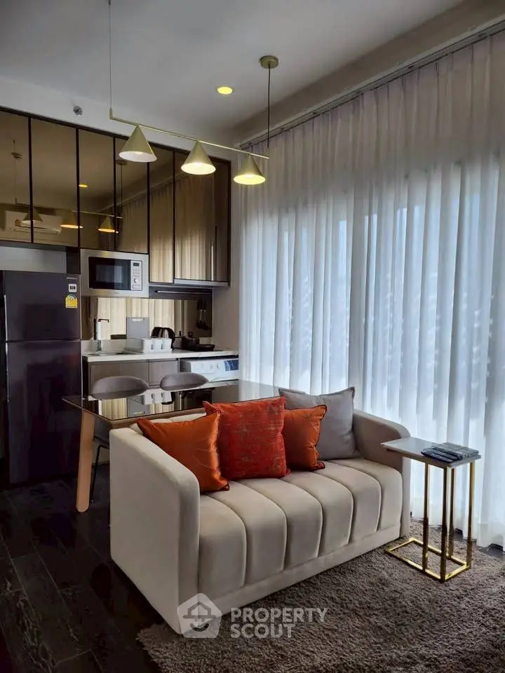 Modern living room with cozy sofa, dining area, and kitchen appliances in a stylish apartment.