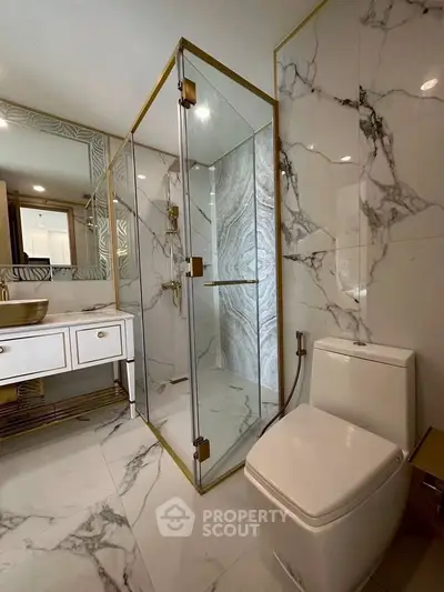 Luxurious bathroom with marble tiles and modern glass shower enclosure