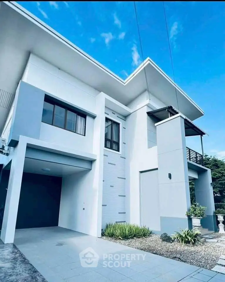 Modern two-story house with sleek design and spacious driveway, perfect for contemporary living.