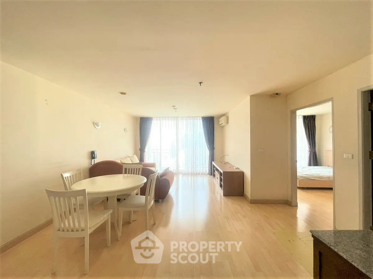 Spacious open-plan living and dining area with natural light and modern furnishings.