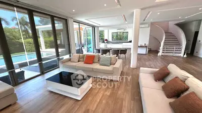 Luxurious open-plan living room with pool view and modern decor