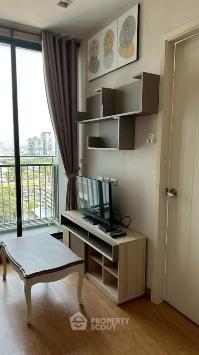 Charming living room with balcony view, modern decor, and natural light in urban apartment.