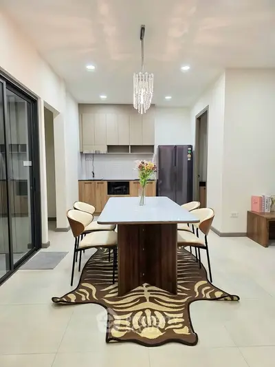 Modern dining area with elegant chandelier and open kitchen layout