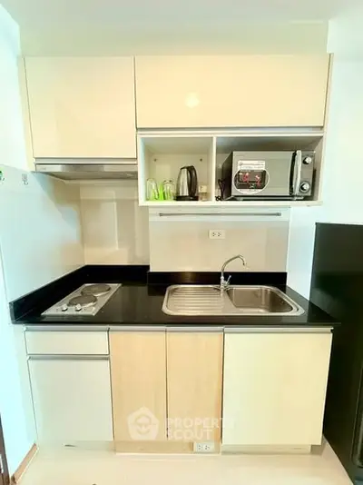 Modern compact kitchen with sleek cabinetry and built-in appliances, perfect for urban living.