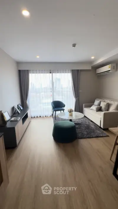 Modern living room with stylish furniture and large window offering city view