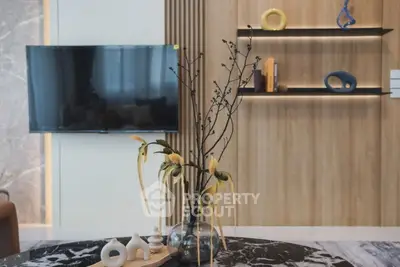 Modern living room with stylish decor and wall-mounted TV, featuring elegant shelves and artistic elements.