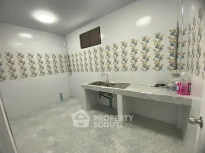 Spacious tiled kitchen with dual sink and floral wall design, perfect for culinary enthusiasts.