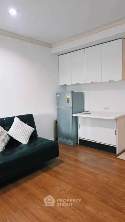 Modern living room with sleek furniture and compact kitchen area, perfect for urban living.