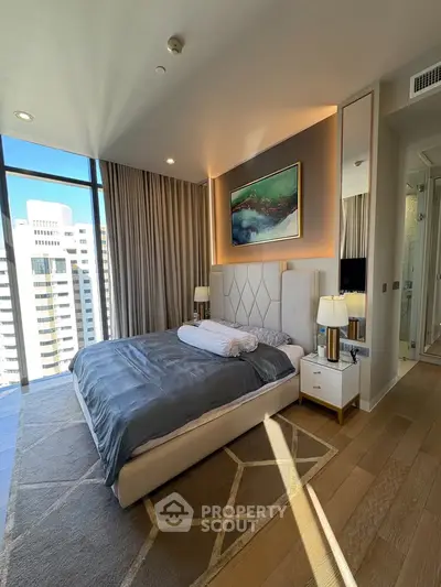 Luxurious bedroom with floor-to-ceiling windows and modern decor in high-rise apartment.