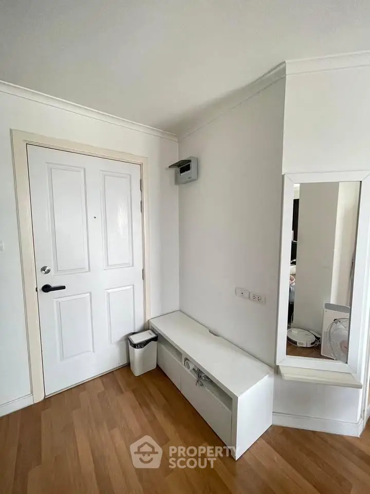Modern entryway with white door, sleek bench, and large mirror
